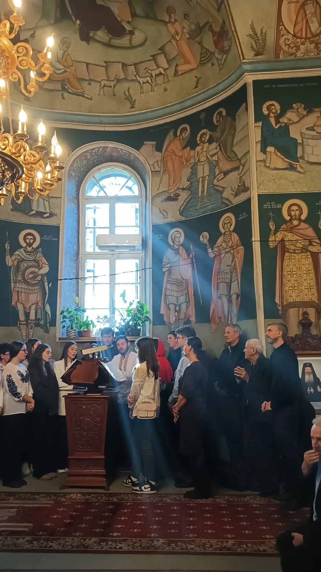 Interiorul bisericii, cu pictura murală și corul la strană